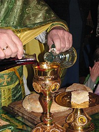 The priest prepares the bread and wine